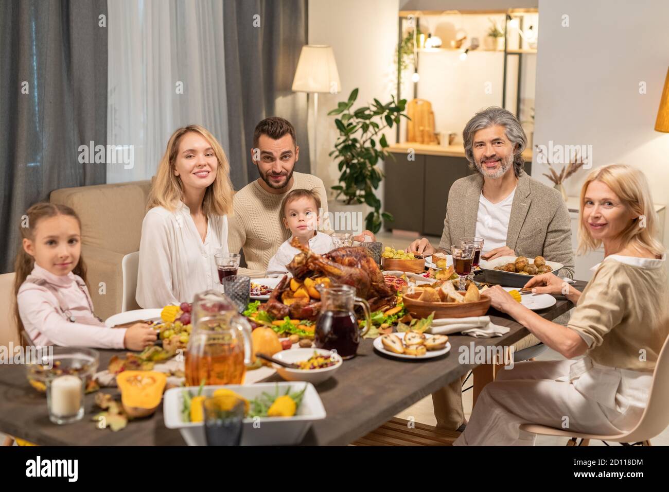 Moderne Familie von drei Generationen, die Abendessen serviert festlich Tabelle Stockfoto