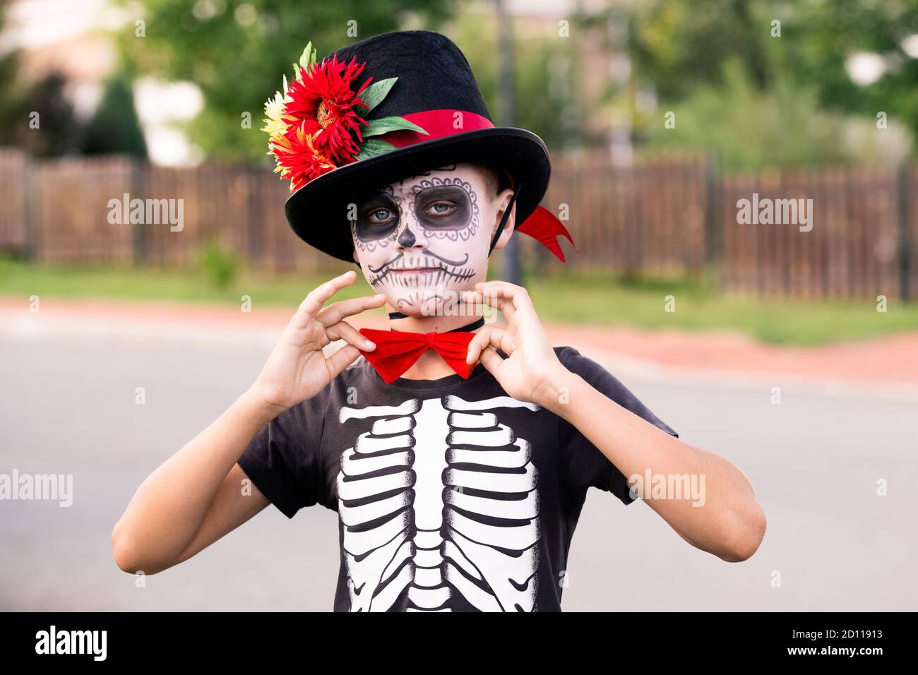 Halloween Junge mit bemalten Gesicht im Kostüm von Skelett mit mütze und rote Fliege Stockfoto