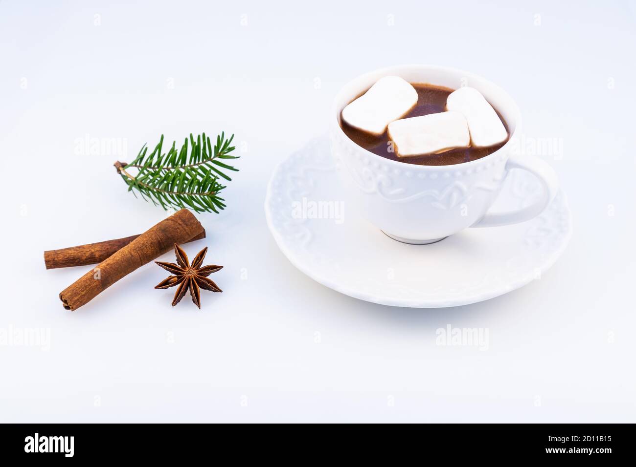 Heiße Schokolade mit Marshmallow, Anasone, Zimt und Christbaumzweigen auf weißem Hintergrund, Draufsicht. Stockfoto