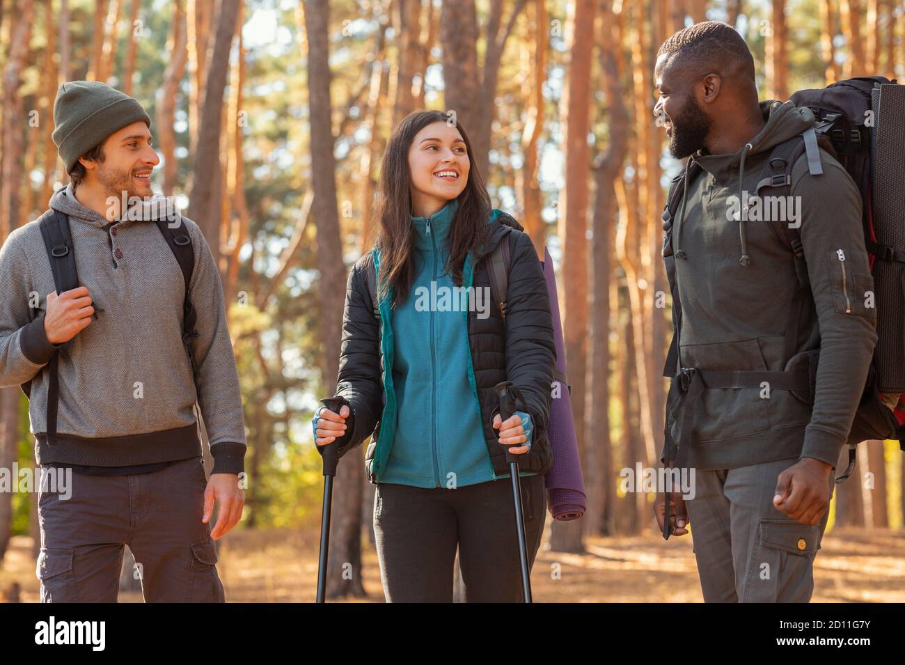 Glückliche Wanderer reden, während Sie durch den Wald gehen Stockfoto