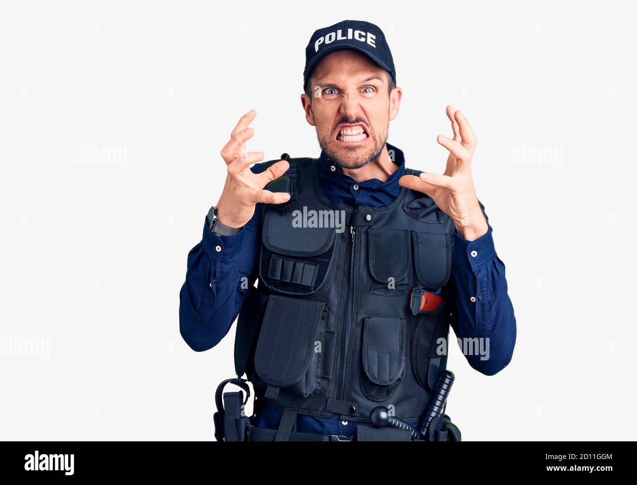 Junger gutaussehender Mann in Polizeiuniform, der mit Wut frustriert schreit, Hände versucht zu erwürgen, wütend schreit Stockfoto