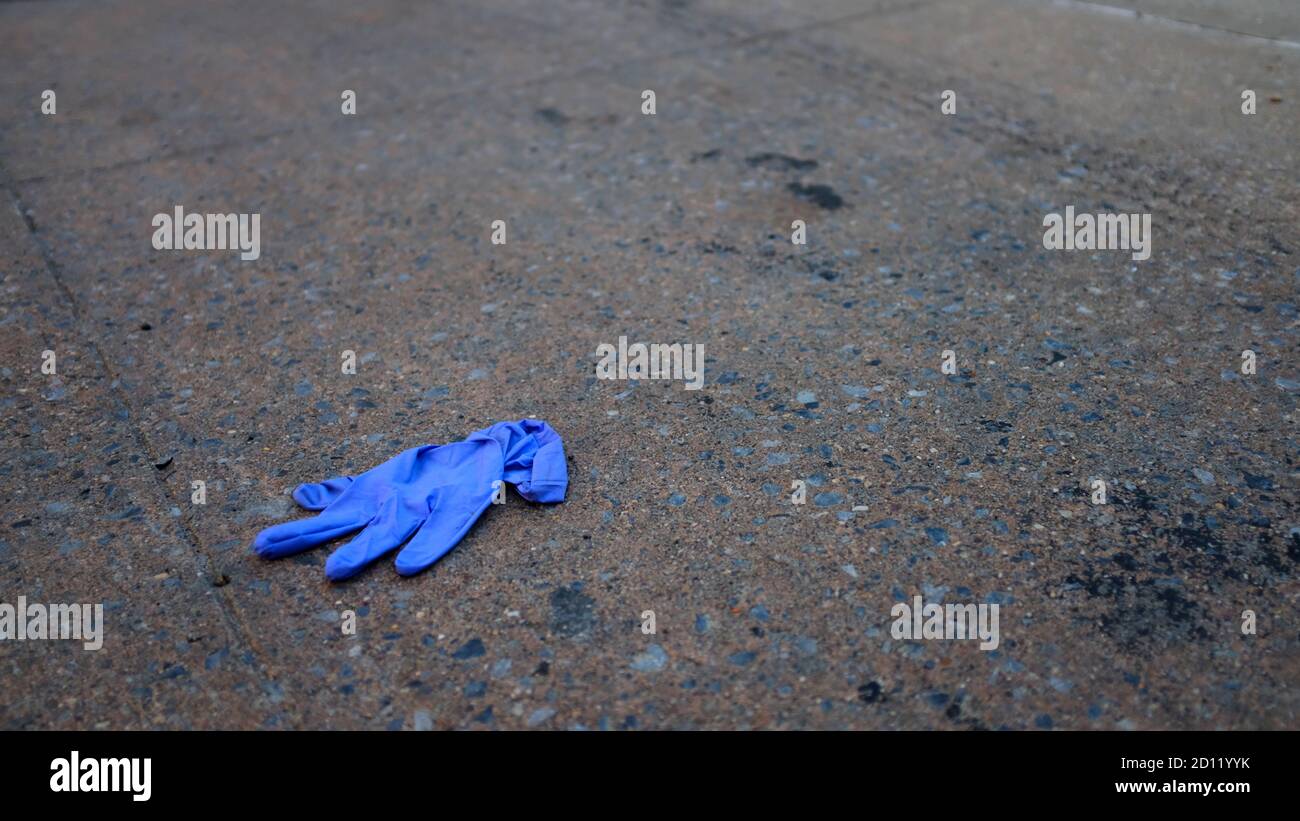 Einweg-Handschuh auf Bürgersteig entsorgt Stockfoto