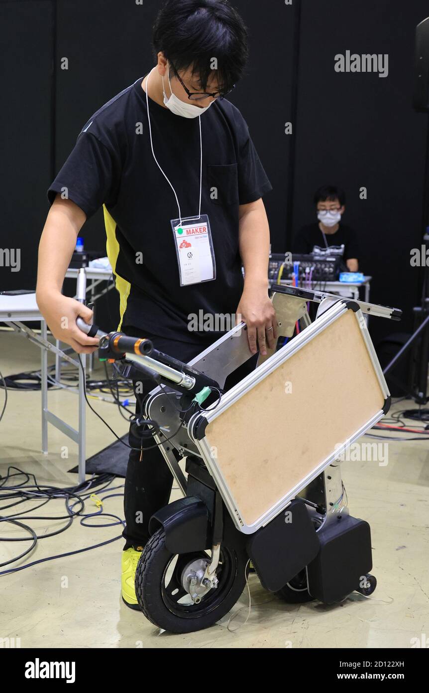 Tokio, Japan. Oktober 2020. Der Groove X Designer Takamitsu Ikoma zeigt am Samstag, den 3. Oktober 2020, bei einem jährlichen DIY Event Maker Faire Tokyo 2020 in Tokio ein Modell eines faltbaren Elektromotorrads "Tatamerubaiku". Die Kofferraumgröße Elektromotorrad kann Kreuzfahrt maximal 70km. Quelle: Yoshio Tsunoda/AFLO/Alamy Live News Stockfoto