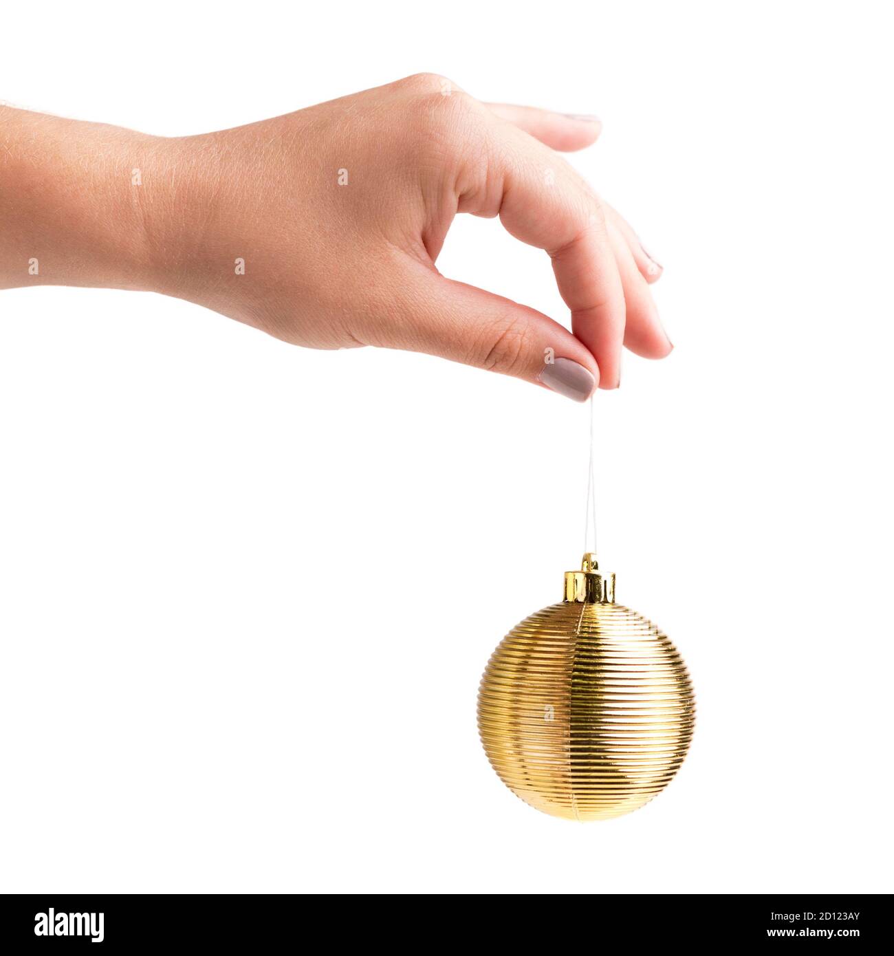Weibliche Hand mit goldenem Weihnachtsball in der Hand Stockfoto