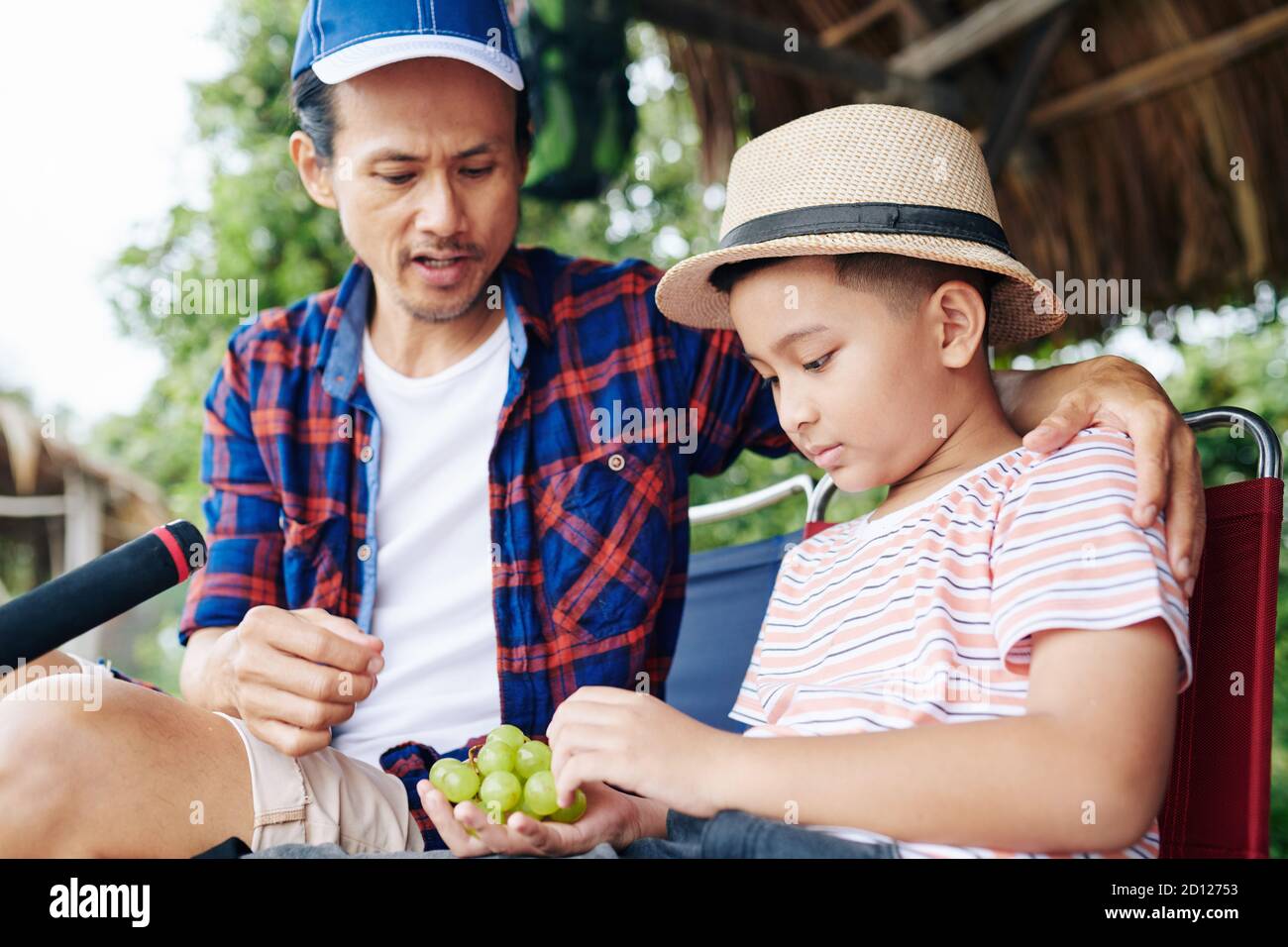 Vater und Sohn essen Trauben Stockfoto