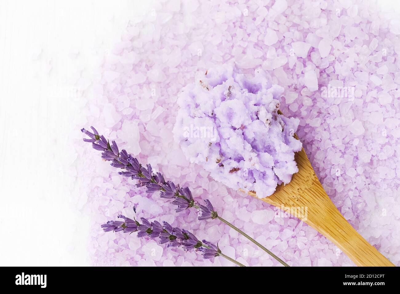 Hausgemachte Lavendel Körper Peeling in Holzlöffel auf Lavendel Bad Salz Hintergrund. Draufsicht, Kopierbereich. SPA-Konzept. Selektiver Fokus Stockfoto