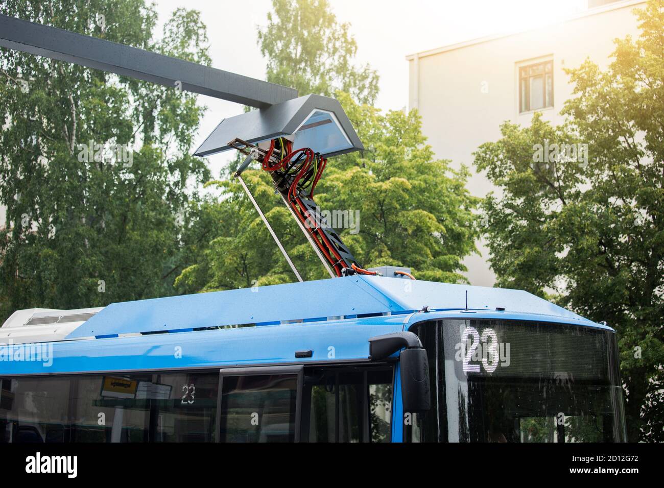 Elektrobus an einer Haltestelle wird von Pantograph geladen Stockfoto