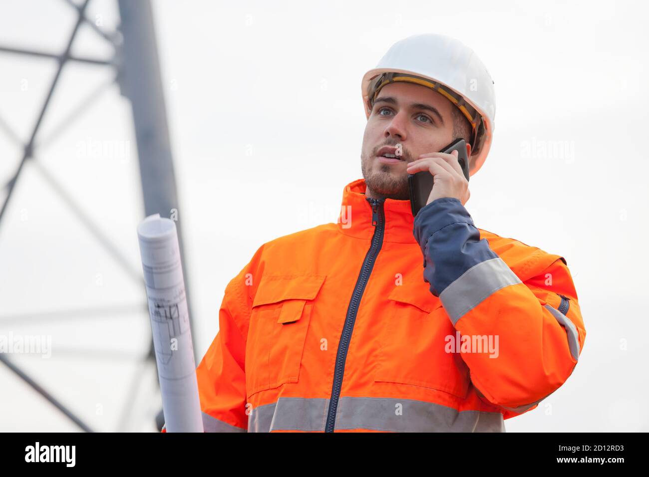 Junger Ingenieur oder Vorarbeiter im Gespräch auf Smartphone auf einem Ölplattform oder Baustelle - selektiver Fokus Stockfoto