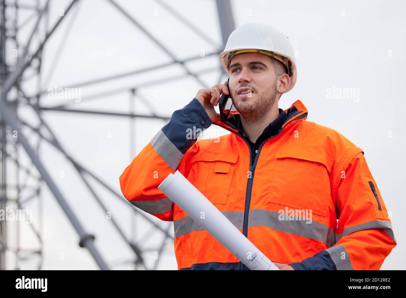 Junger Ingenieur oder Vorarbeiter im Gespräch auf Smartphone auf einem Ölplattform oder Baustelle - selektiver Fokus Stockfoto