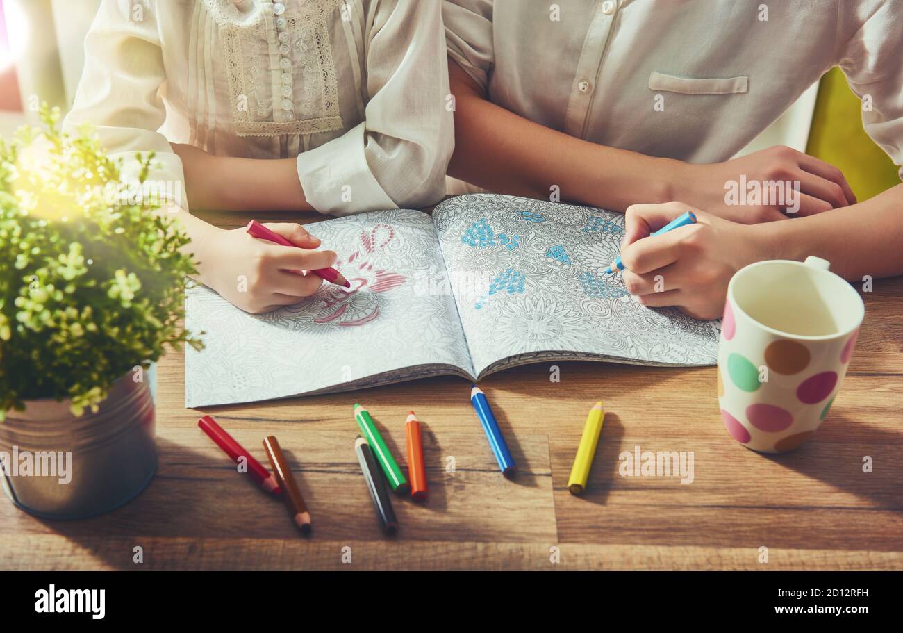 Kind und Erwachsener malen ein Malbuch. Neuer Trend zur Stressabbau. Konzept Achtsamkeit, Entspannung. Stockfoto