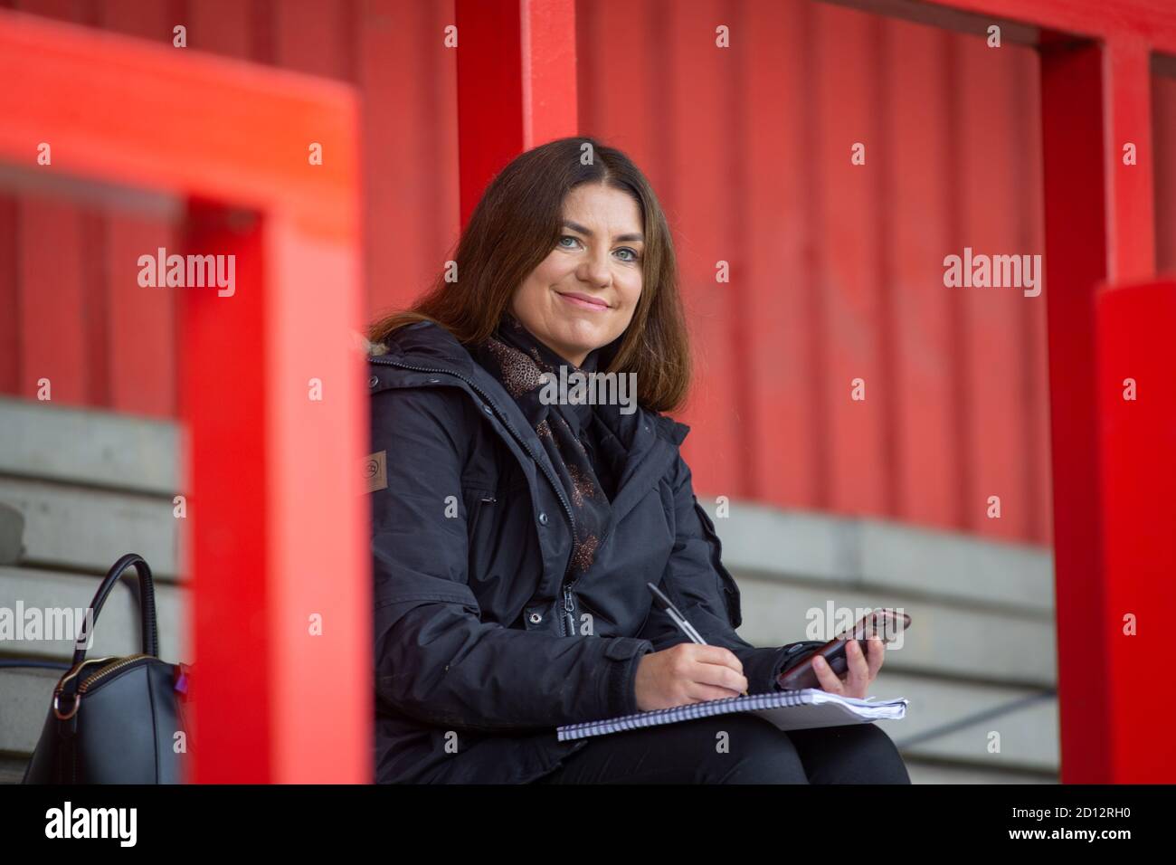 Sky Sports-Reporterin Bianca Westwood sitzt auf der leeren Terrasse im Lamex-Stadion, Stevenage bereitet Notizen vor Spielbeginn vor Stockfoto
