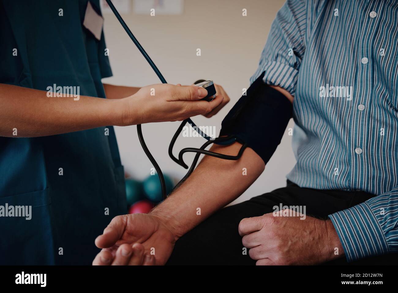 Nahaufnahme der Hände der jungen Krankenschwester, die den Blutdruck des Patienten messen Stockfoto