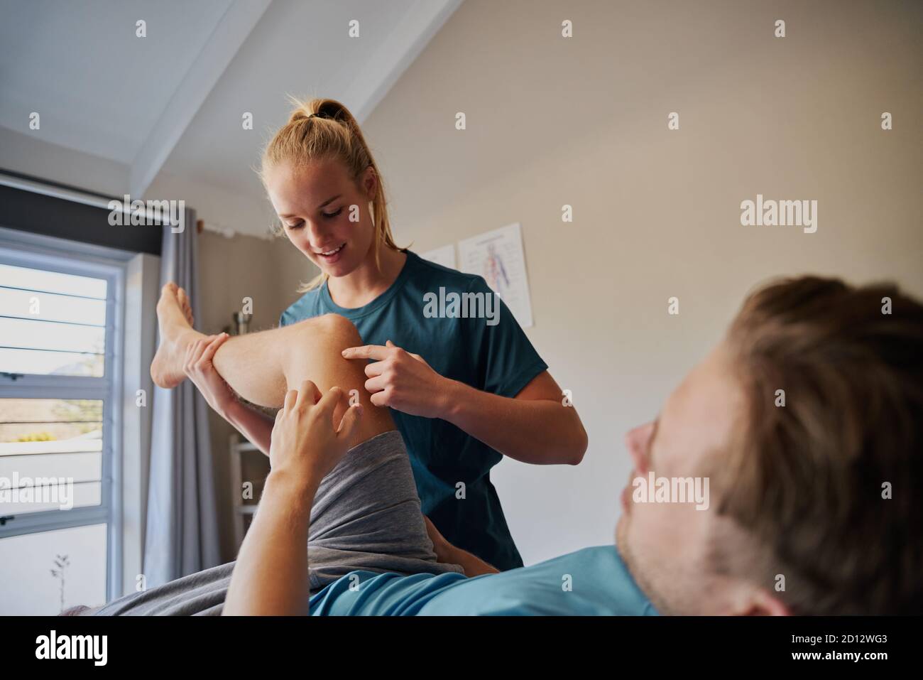 Physiotherapeut hilft Patienten mit Knieschmerzen - Patient mit Läufern Knie Stockfoto