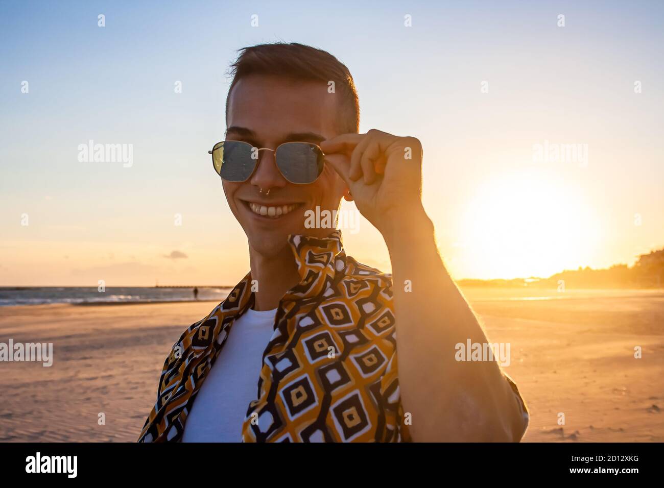 Junger Mann Sonnenuntergang Porträt mit Sonnenbrille. Mittlere Aufnahme. Stockfoto