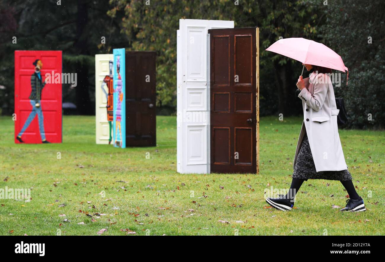 Eine Frau geht an Lubaina Himid's "Five Conversations" vorbei, die als Teil der Frieze Sculpture 2020 Ausstellung im English Gardens im Regent's Park, London, installiert wurde und Arbeiten von 12 führenden internationalen Künstlern zeigt. Stockfoto