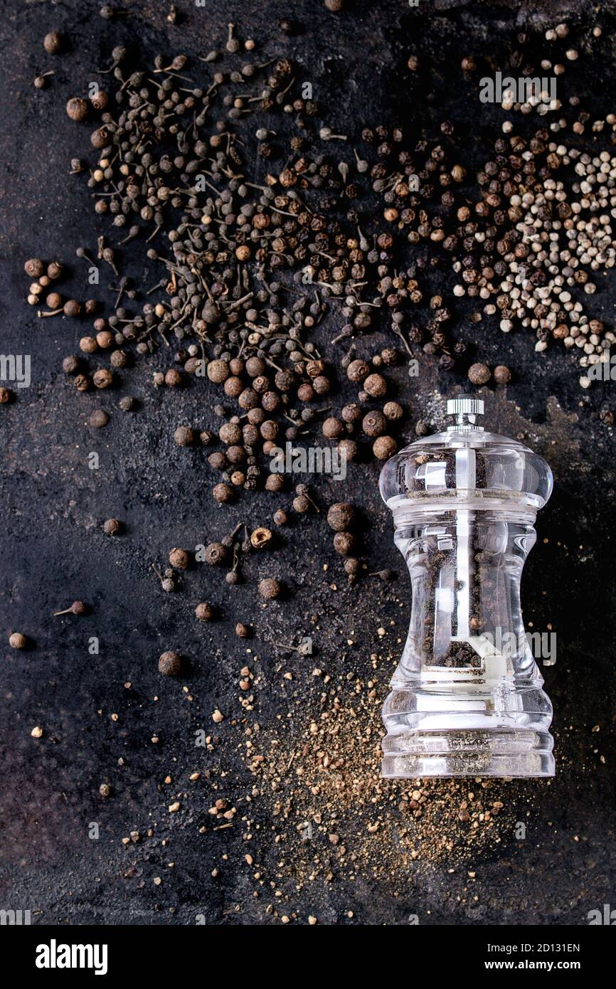 Vielzahl von verschiedenen schwarzen Pfeffer Piment, Pfeffer, Langer Pfeffer, Mönche Pfeffer, Pfefferkörner und Boden Pulver von transparent Pfeffer Mühle auf alten b Stockfoto