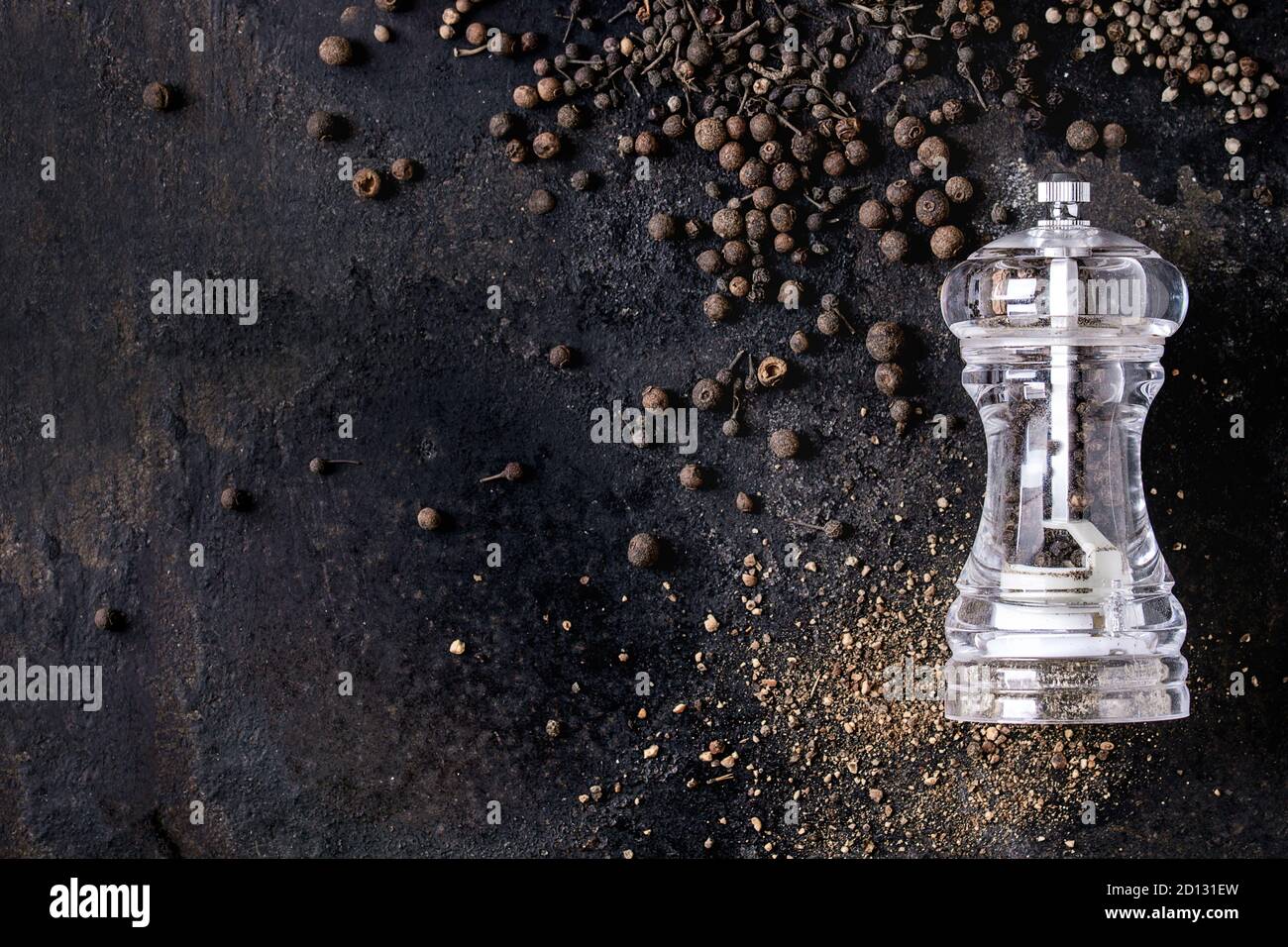 Vielzahl von verschiedenen schwarzen Pfeffer Piment, Pfeffer, Langer Pfeffer, Mönche Pfeffer, Pfefferkörner und Boden Pulver von transparent Pfeffer Mühle auf alten b Stockfoto