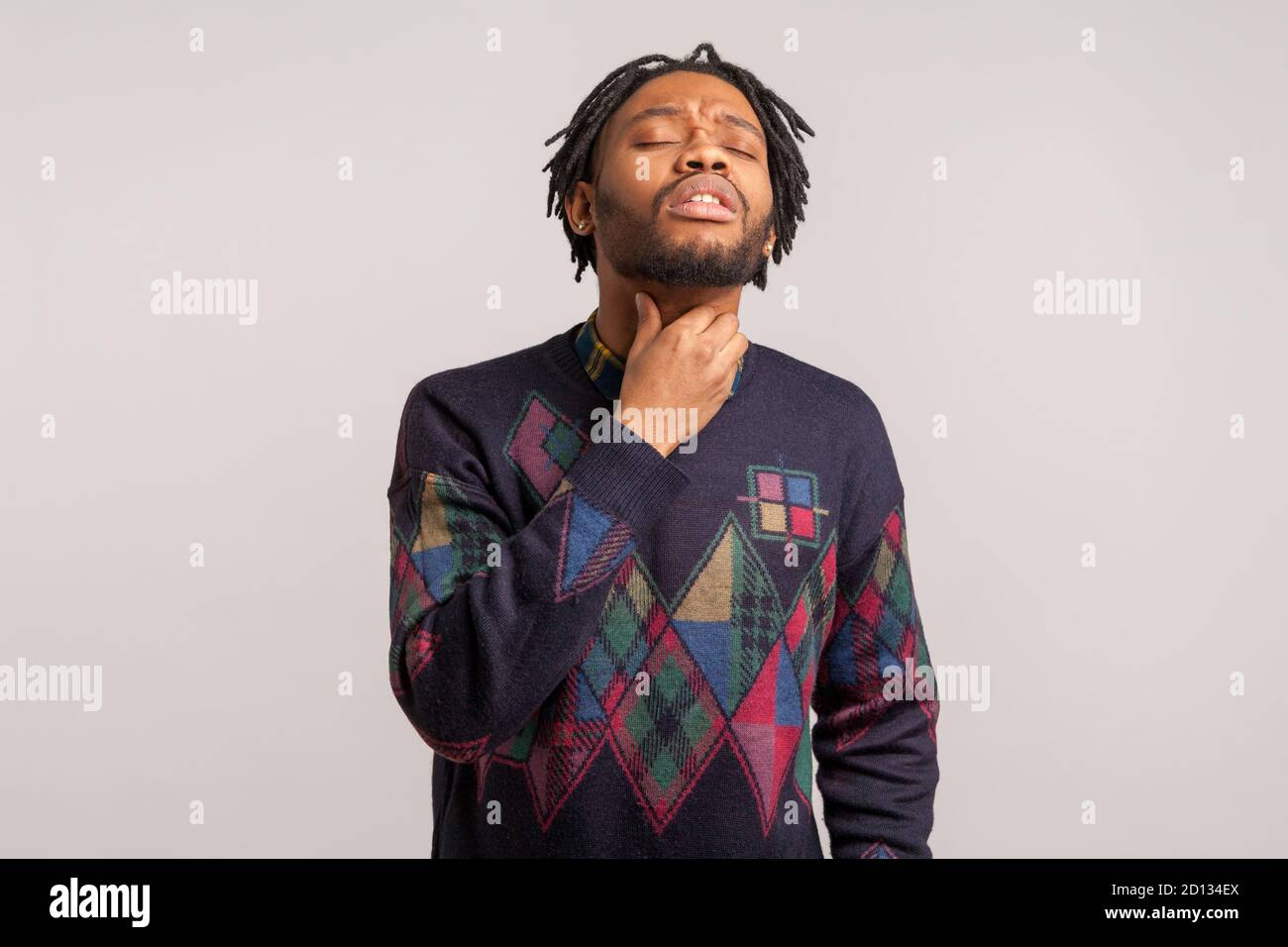Depressiver afrikanischer Mann mit Bart berühren Hals Gefühl Beschwerden beim Schlucken, Halsschmerzen, Mandelentzündung. Innenaufnahme des Studios isoliert auf grauem Rücken Stockfoto