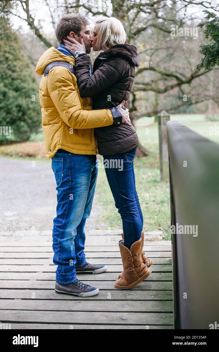 Junges Paar küsst draußen an einem kalten Wintertag. Stockfoto