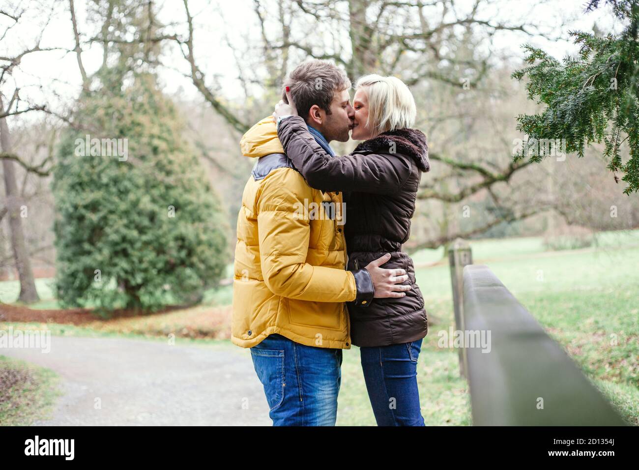 Junges Paar küsst draußen an einem kalten Wintertag. Stockfoto