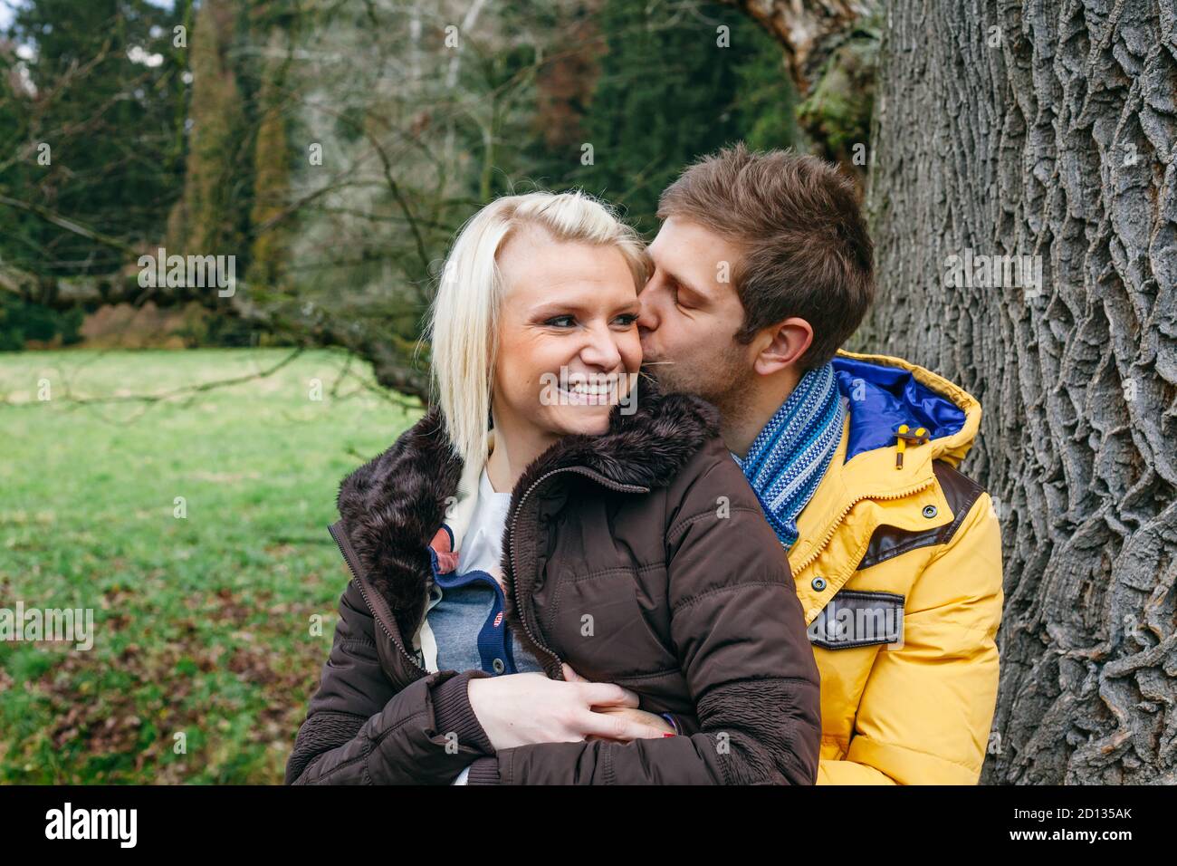 Junges Paar küsst draußen an einem kalten Wintertag. Stockfoto