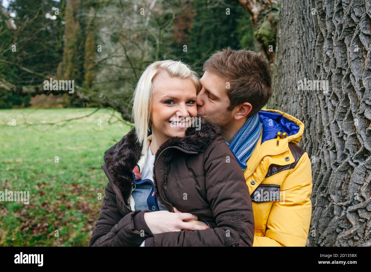 Junges Paar küsst draußen an einem kalten Wintertag. Stockfoto