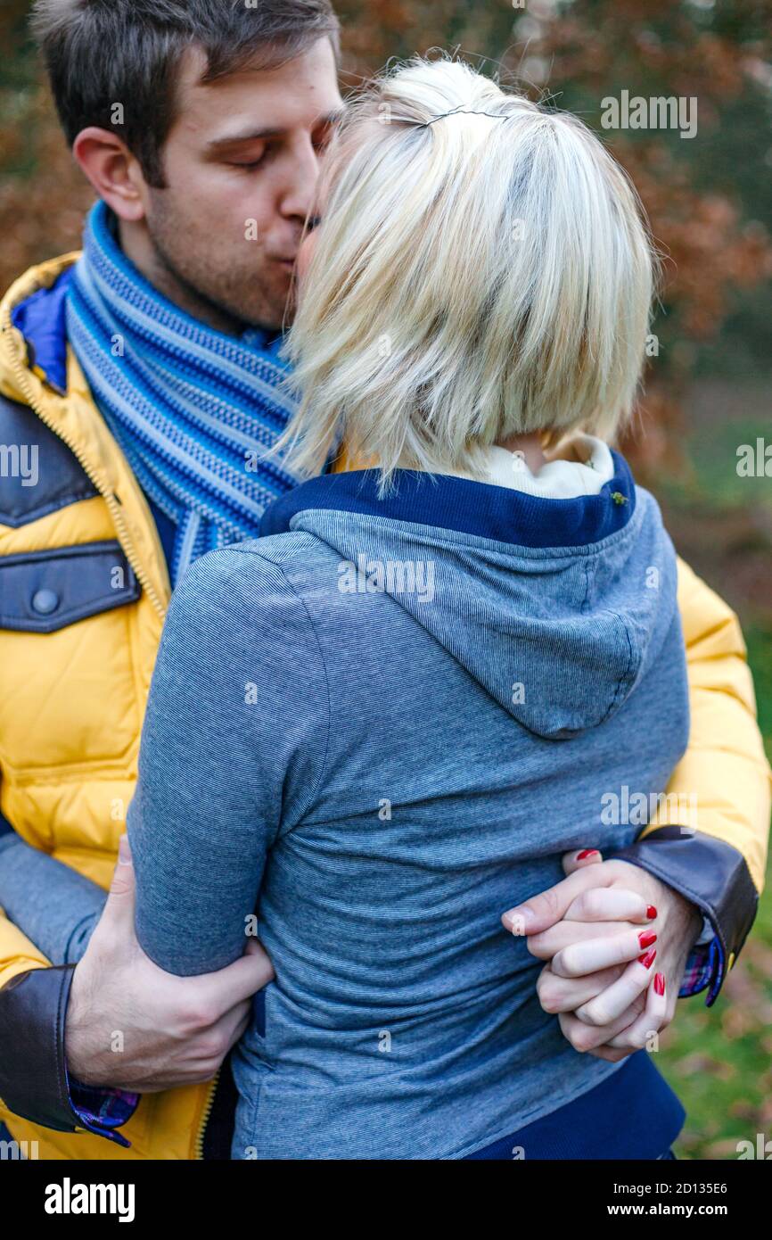Junges Paar küsst draußen an einem kalten Wintertag. Stockfoto
