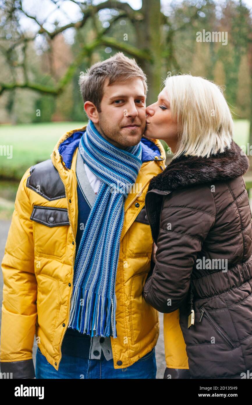 Junges Paar küsst draußen an einem kalten Wintertag. Stockfoto