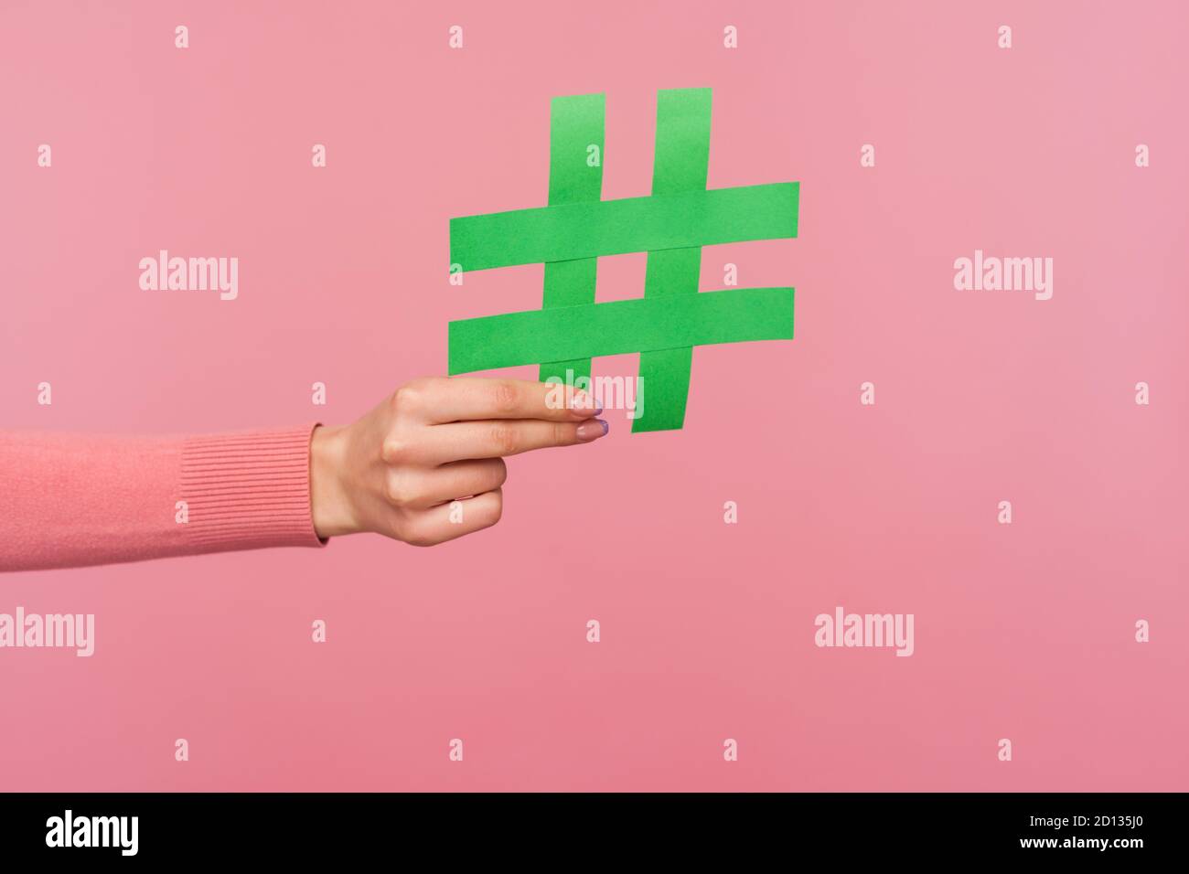 Treten Sie dem beliebten Blog bei! Nahaufnahme der weiblichen Hand mit grünem Hashtag-Zeichen, teilen getaggte Nachricht, empfehlen folgen Trends. Innenaufnahme des Studios isoliert Stockfoto