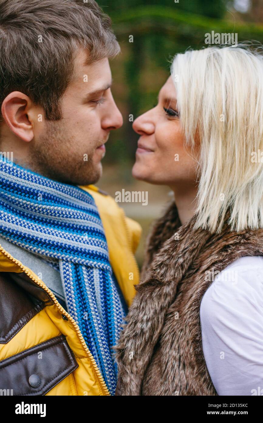 Junges Paar küsst draußen an einem kalten Wintertag. Stockfoto