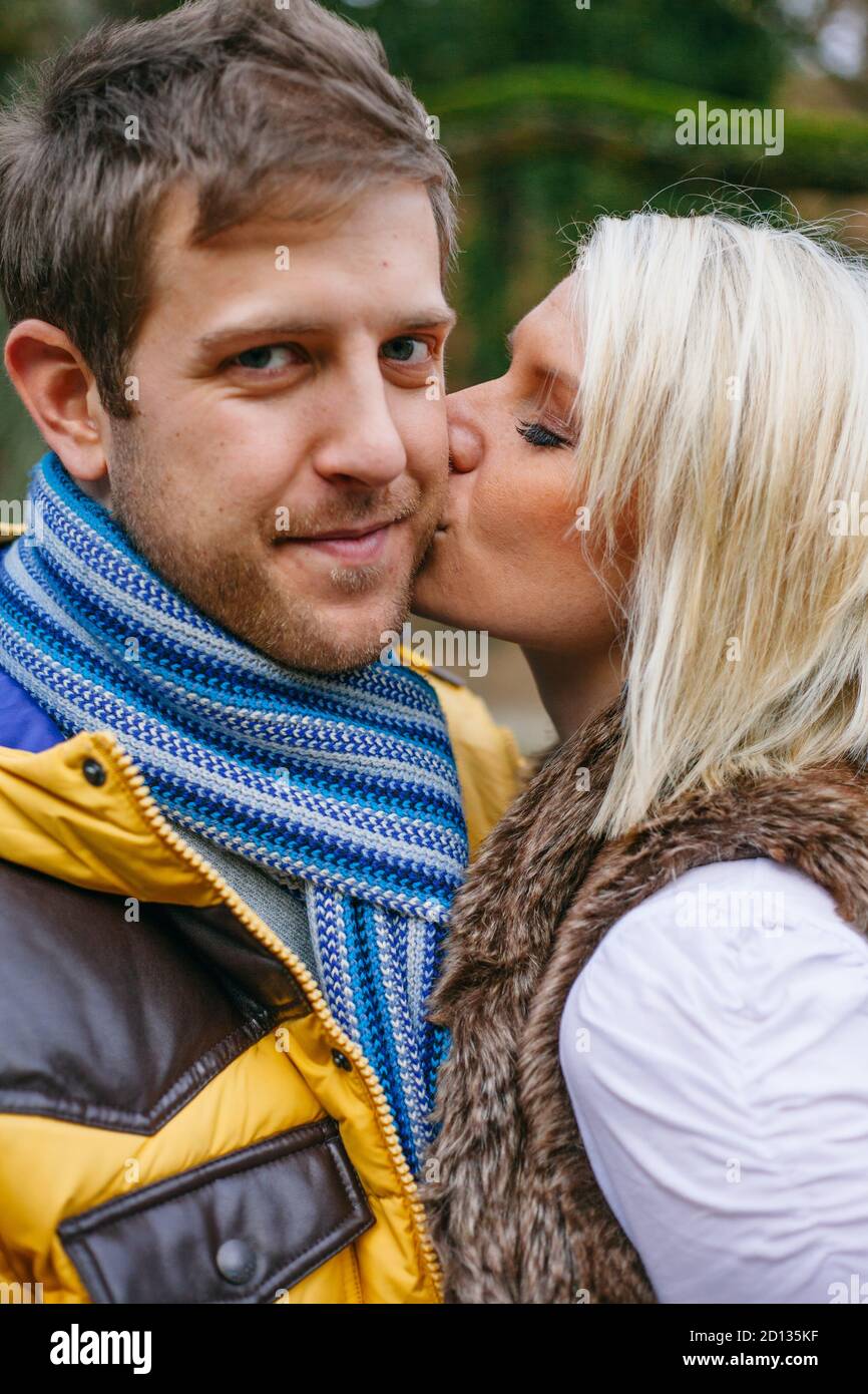 Junges Paar küsst draußen an einem kalten Wintertag. Stockfoto