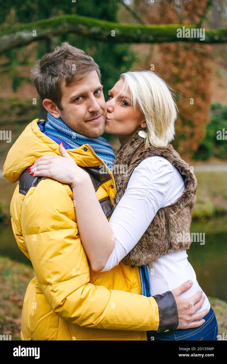 Junges Paar küsst draußen an einem kalten Wintertag. Stockfoto