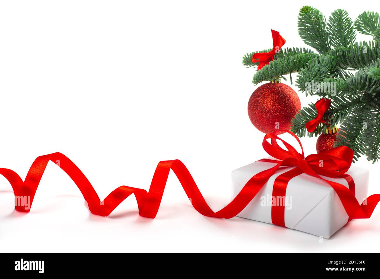 Weiße Feiertag Geschenk-Geschenkbox mit roten Satinschleife und lockiges Band unter Weihnachtsbaum mit Kugeln, Rahmen Rahmen Design isoliert auf weißem Hintergrund Stockfoto