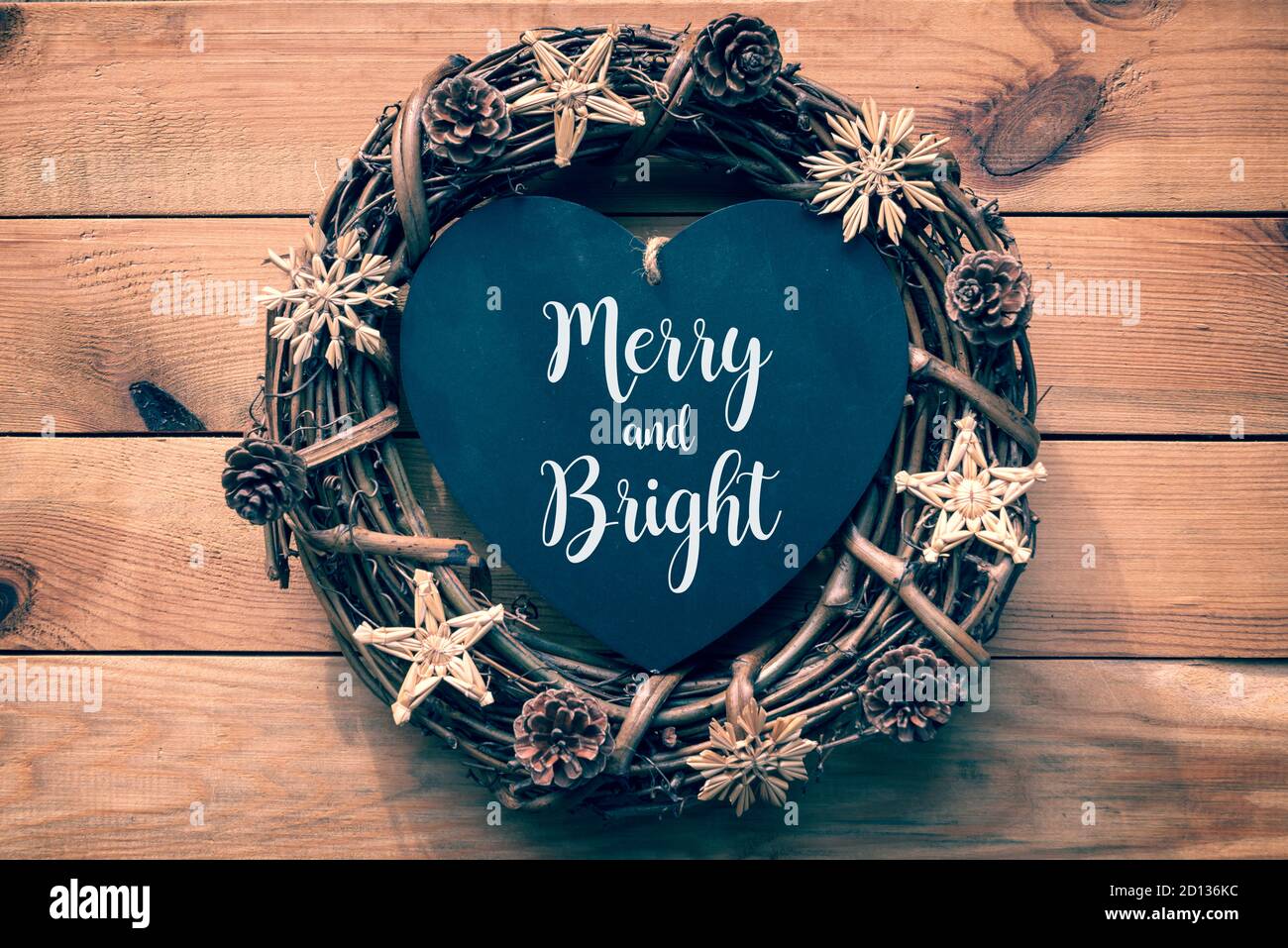 Frohe und helle Weihnachtskarte. Rustikaler Weihnachtskranz auf Holzplanken Hintergrund Stockfoto