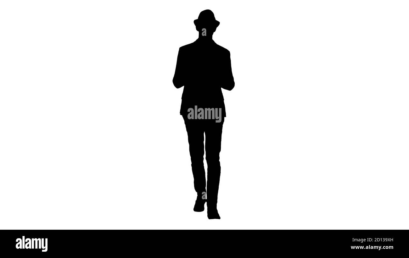 Silhouette Gelegenheitlicher Mann in einem Hut zu Fuß und zeigt digitale Tablette zur Kamera. Stockfoto