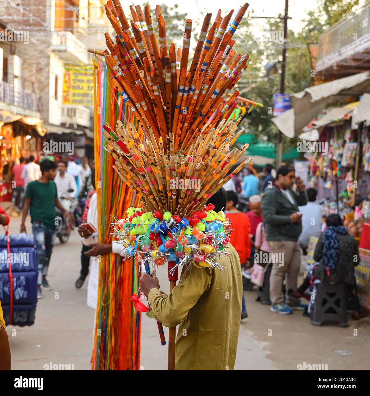 Ein Mann, der Flöten und Plastikspielzeug verkauft, das auf seiner Schulter auf den Straßen von Pushkar, Rajasthan, Indien, am 10. November 2018 angezeigt wird Stockfoto Ein Mann, der Flöten und Plastikspielzeug verkauft, das auf seiner Schulter auf den Straßen von Pushkar, Rajasthan, Indien, am 10. November 2018 angezeigt wird Stockfoto