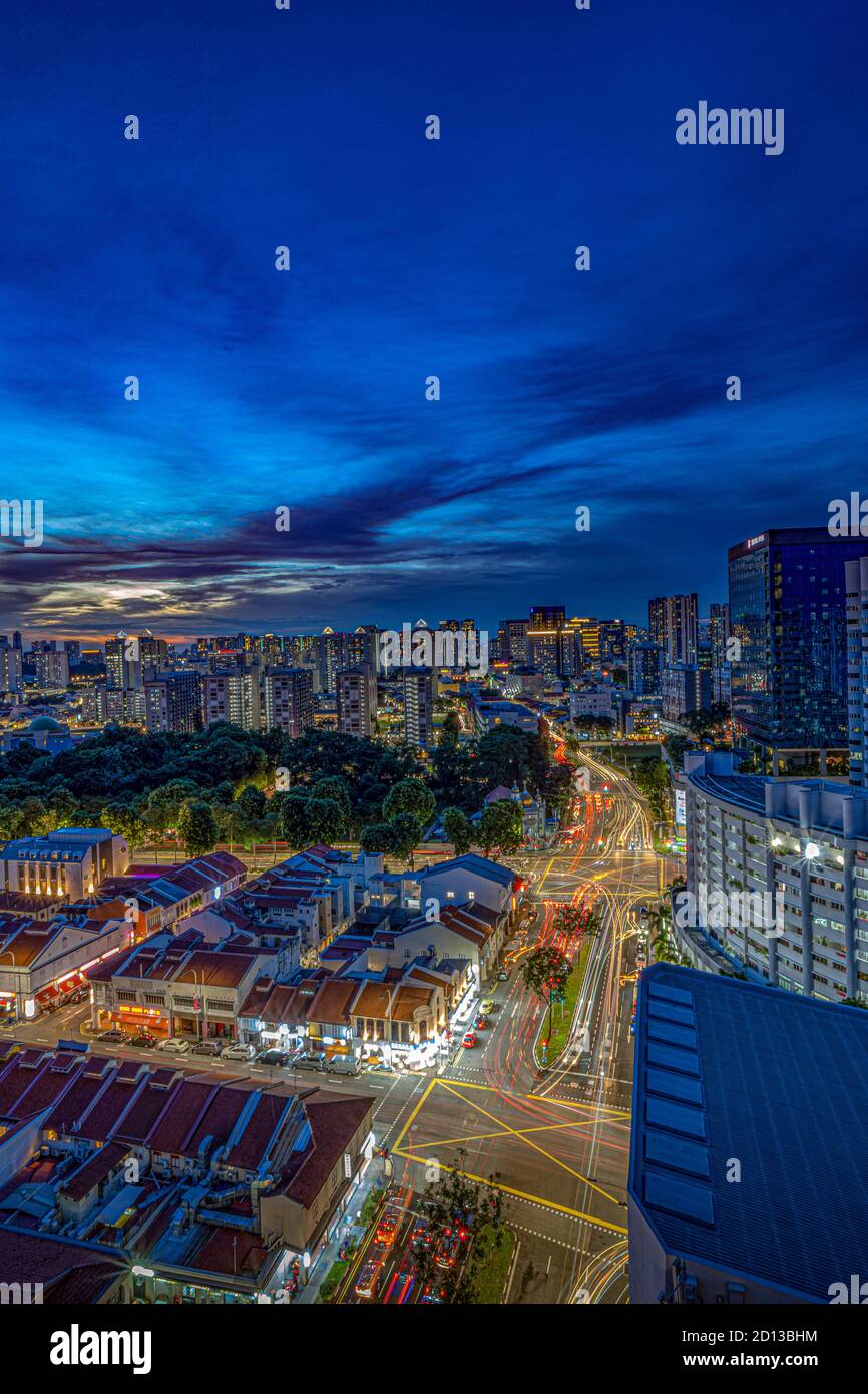 Lange Exposition von Autos Licht Wanderwege in Singapur Stadt gegen Wohn- und ikonische Stadt- und Denkmalarchitektur Stockfoto