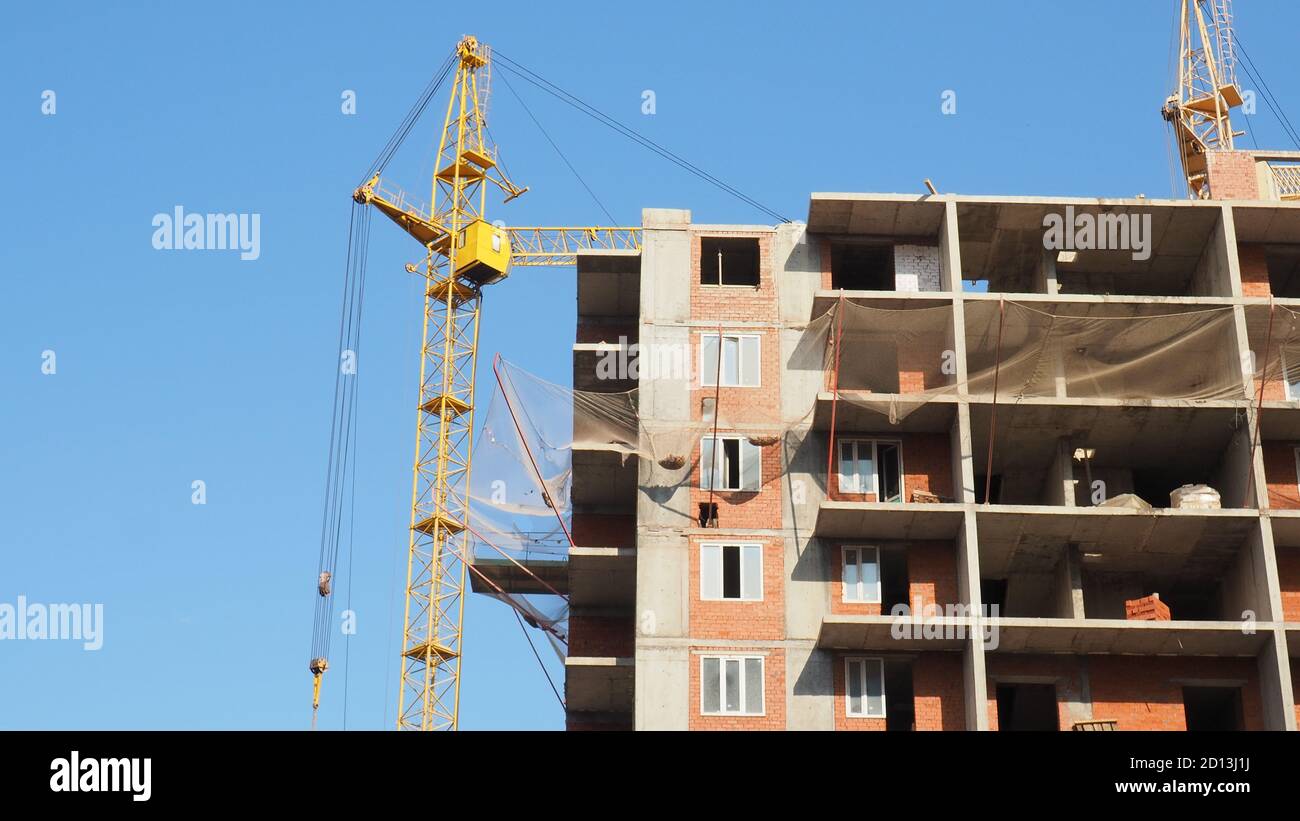 Arbeiten auf Platz mit vielen Hochhäuser im Bau und Krane unter blauem Himmel Stockfoto