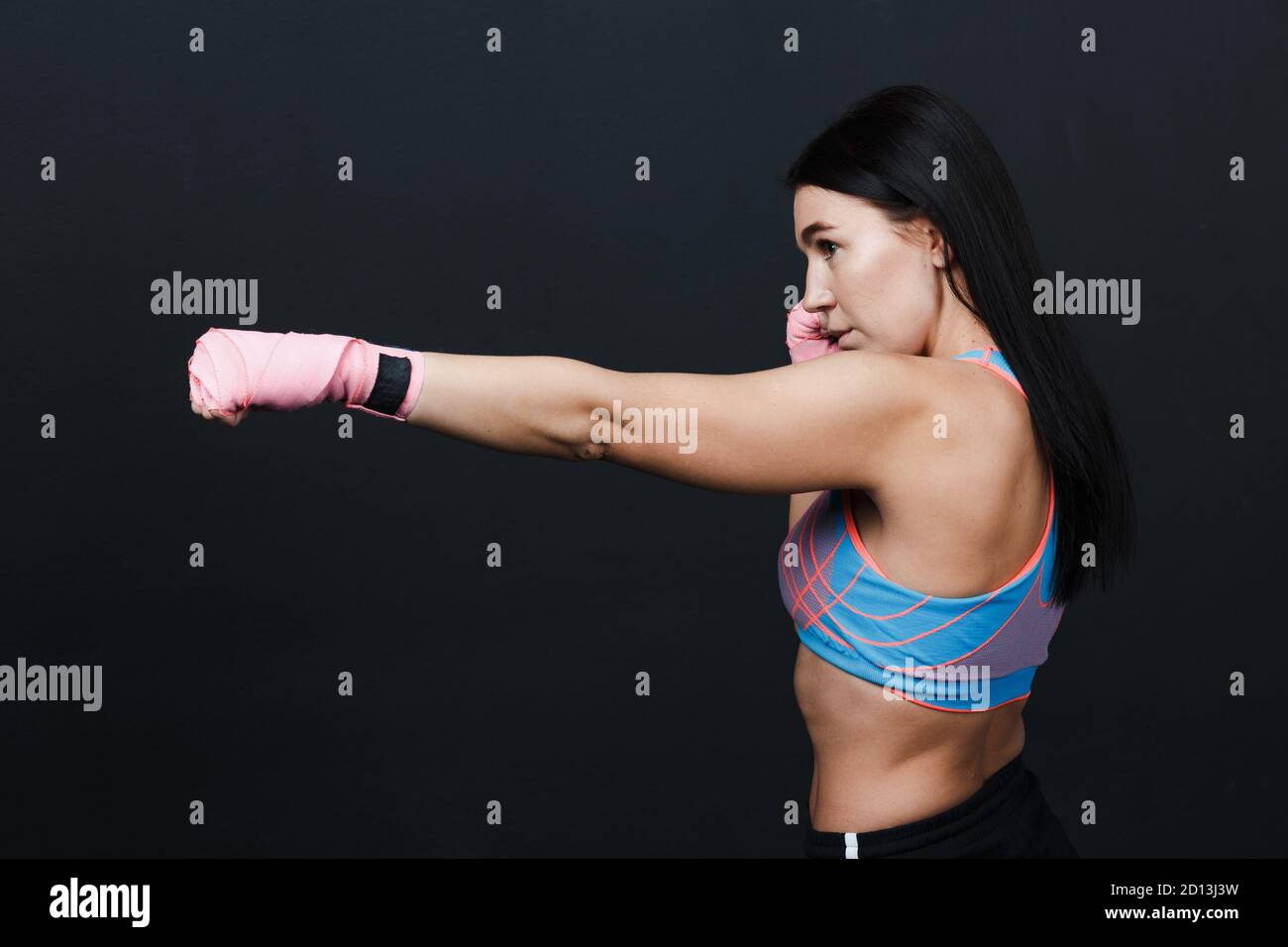 Sportsman muay thai starke Frau Boxer posiert im Trainingsstudio auf schwarzem Hintergrund. Stockfoto