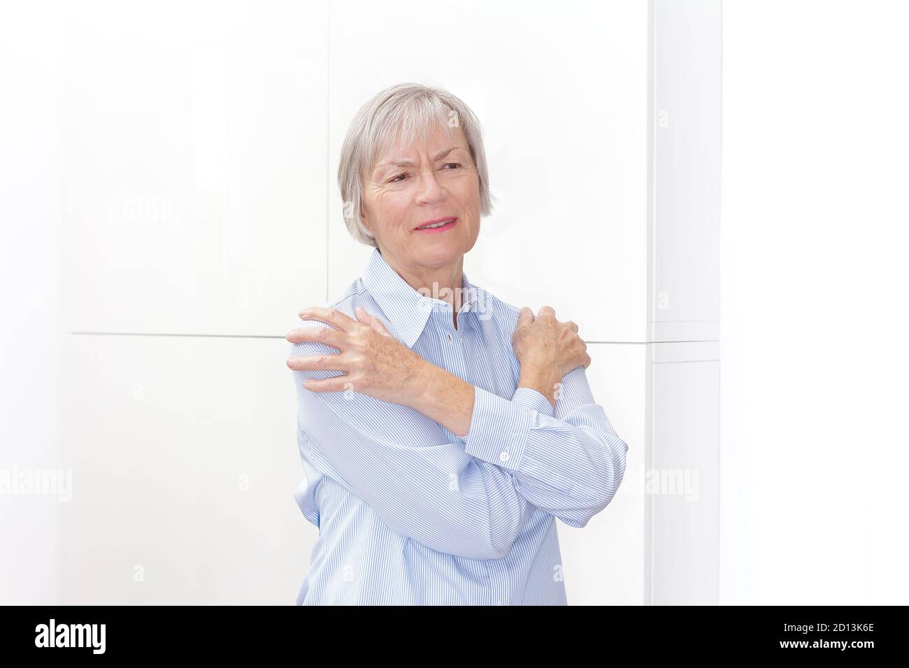 Polymyalgia rheumatica: Ältere Frau mit akuten Schmerzen in den Oberarmen. Stockfoto