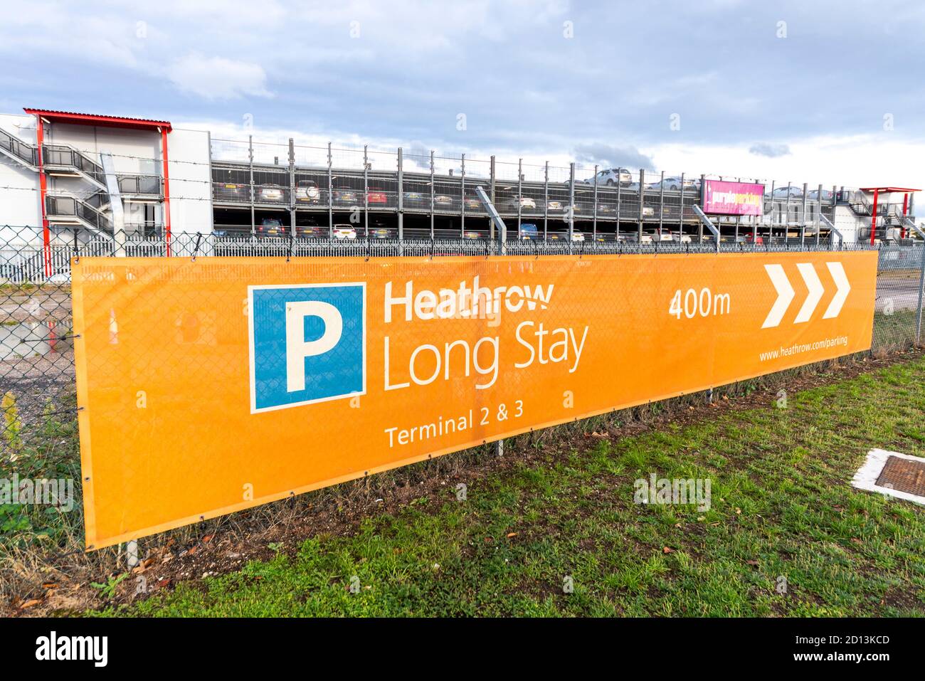 Heathrow Long Stay Parkschild, mit Purple Parking Parkhaus und Autos. Parkplätze an der nördlichen Umzäunungsstraße. Parkgarage Ebenen Stockfoto