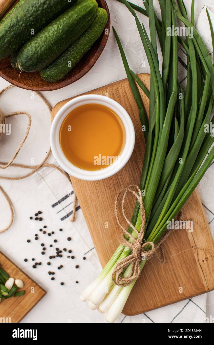 Grüne frische grüne Zwiebel gebunden Bündel auf einem Holzbrett mit Pflanzenöl. Foodfoto für ecomarket und für Vegetarier. Stockfoto
