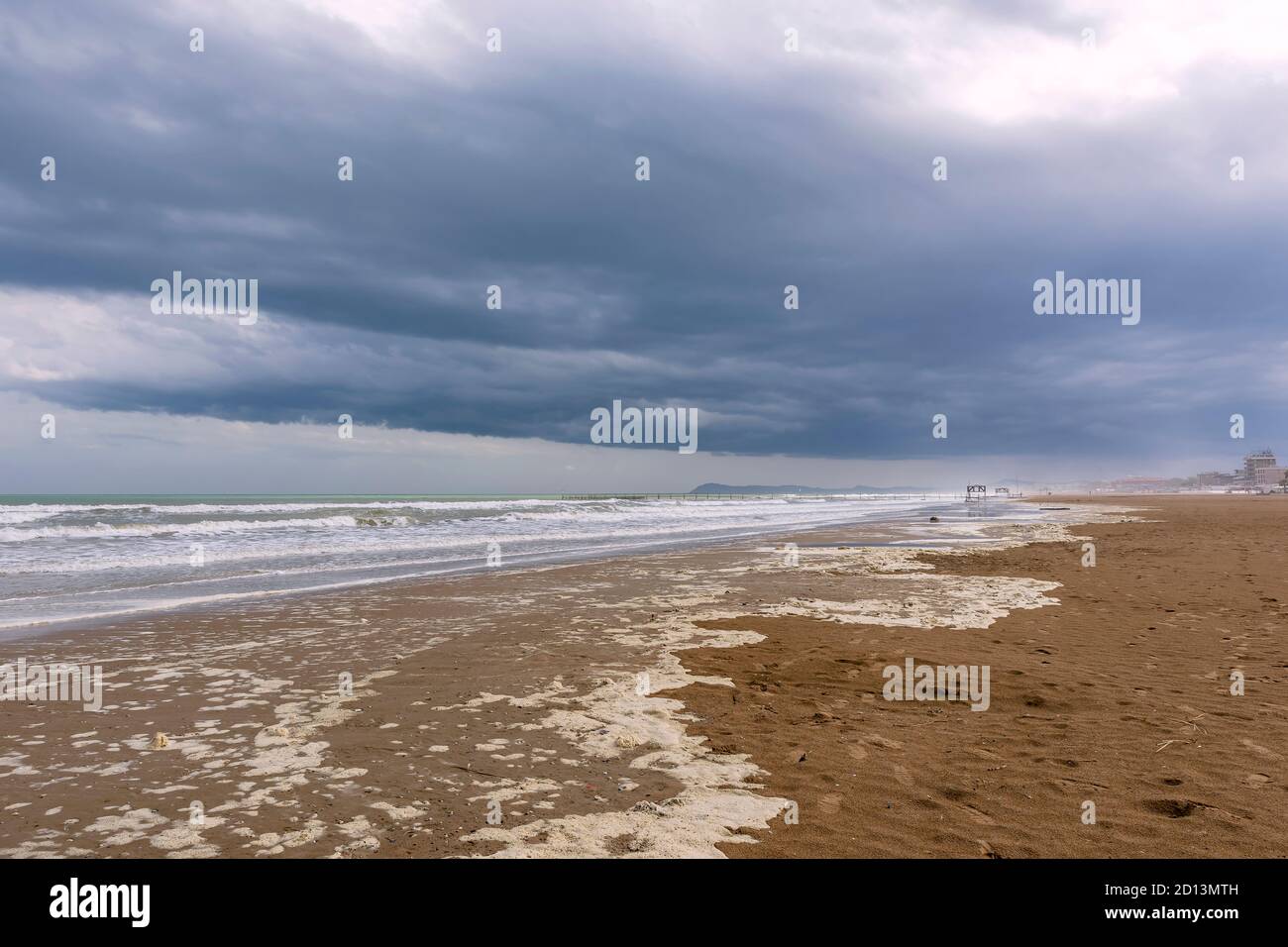 Der lange und breite Strand von Rimini, Emilia Romagna, Italien, unter einem dramatischen Himmel in der Wintersaison Stockfoto