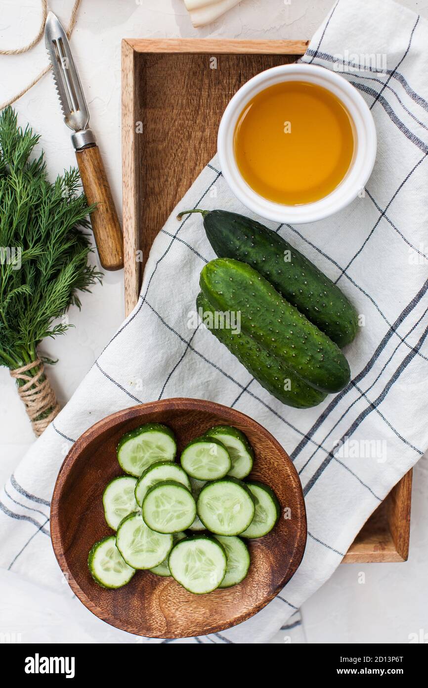 Frische Gurken ganz und in Scheiben geschnitten in einem Holzteller. Foodfoto für ecomarket und Menü für Vegetarier. Stockfoto