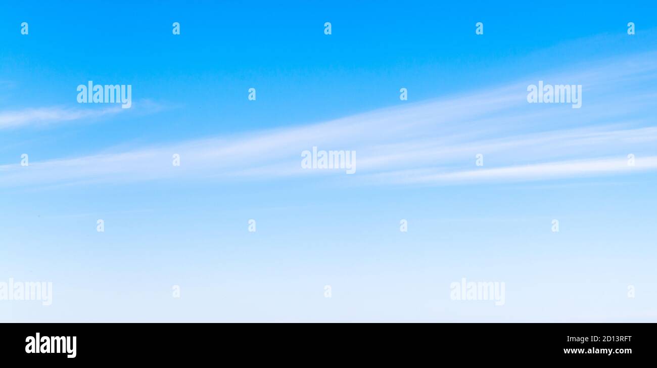 Blauer Himmel mit Streifen von weißen windigen Wolken am Tag, natürliche Panorama Hintergrund Foto Textur Stockfoto