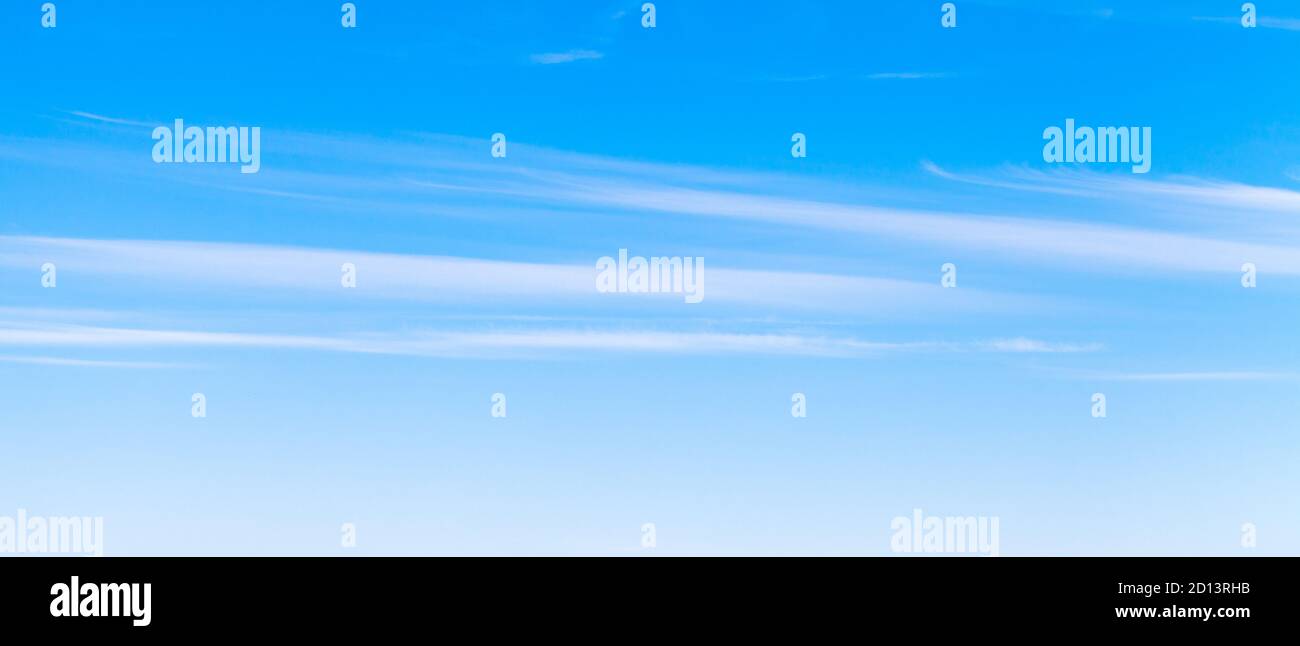 Blauer Himmel mit Streifen von weißen Cirrus Wolken am Tag, natürliche Panorama Hintergrund Foto Textur Stockfoto