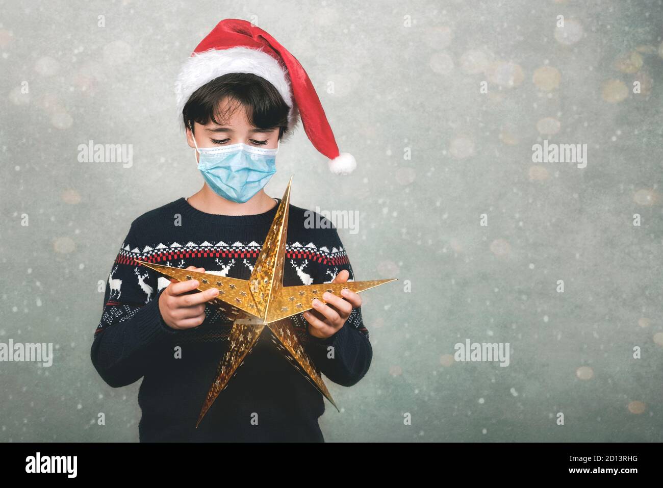 Frohe Weihnachten, Kind mit medizinischer Maske und weihnachtsstern über grau Hintergrund Stockfoto