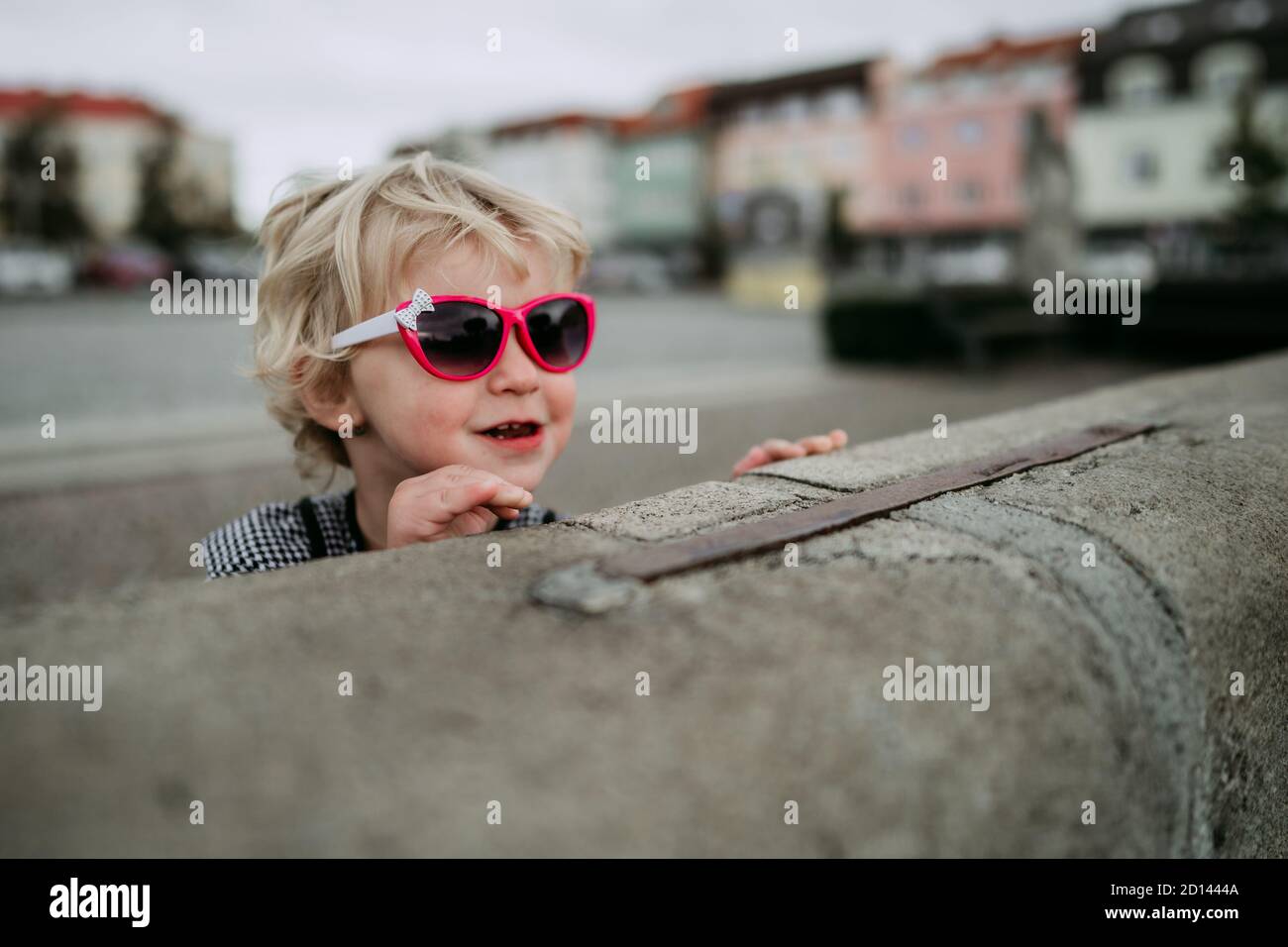 Kleines Mädchen mit Sonnenbrille in der Stadt Stockfoto