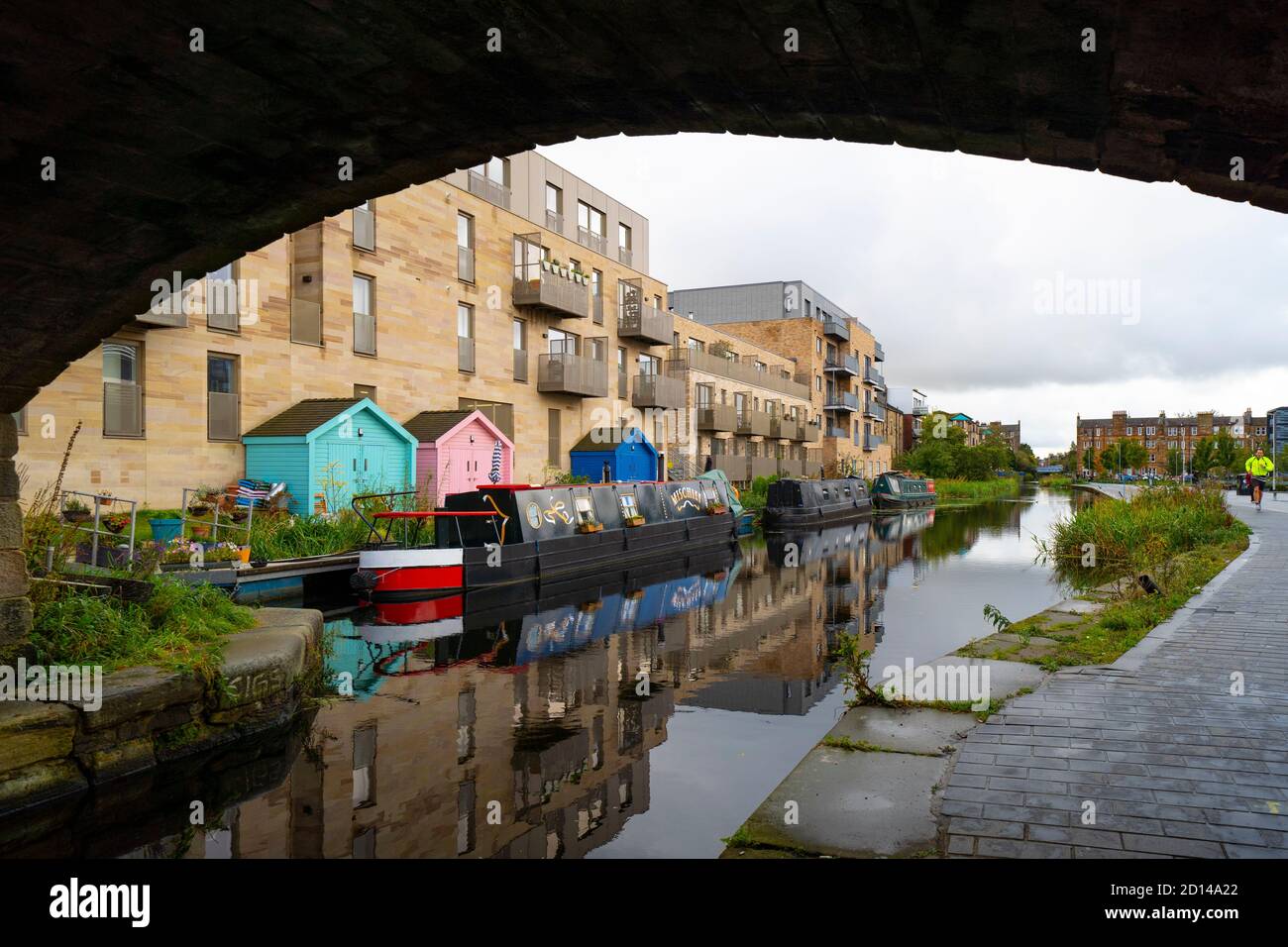 Moderne Wohnblocks und schmale Boote, die am Union Canal bei Fountainbridge in Edinburgh, Schottland, Großbritannien, festgemacht sind Stockfoto