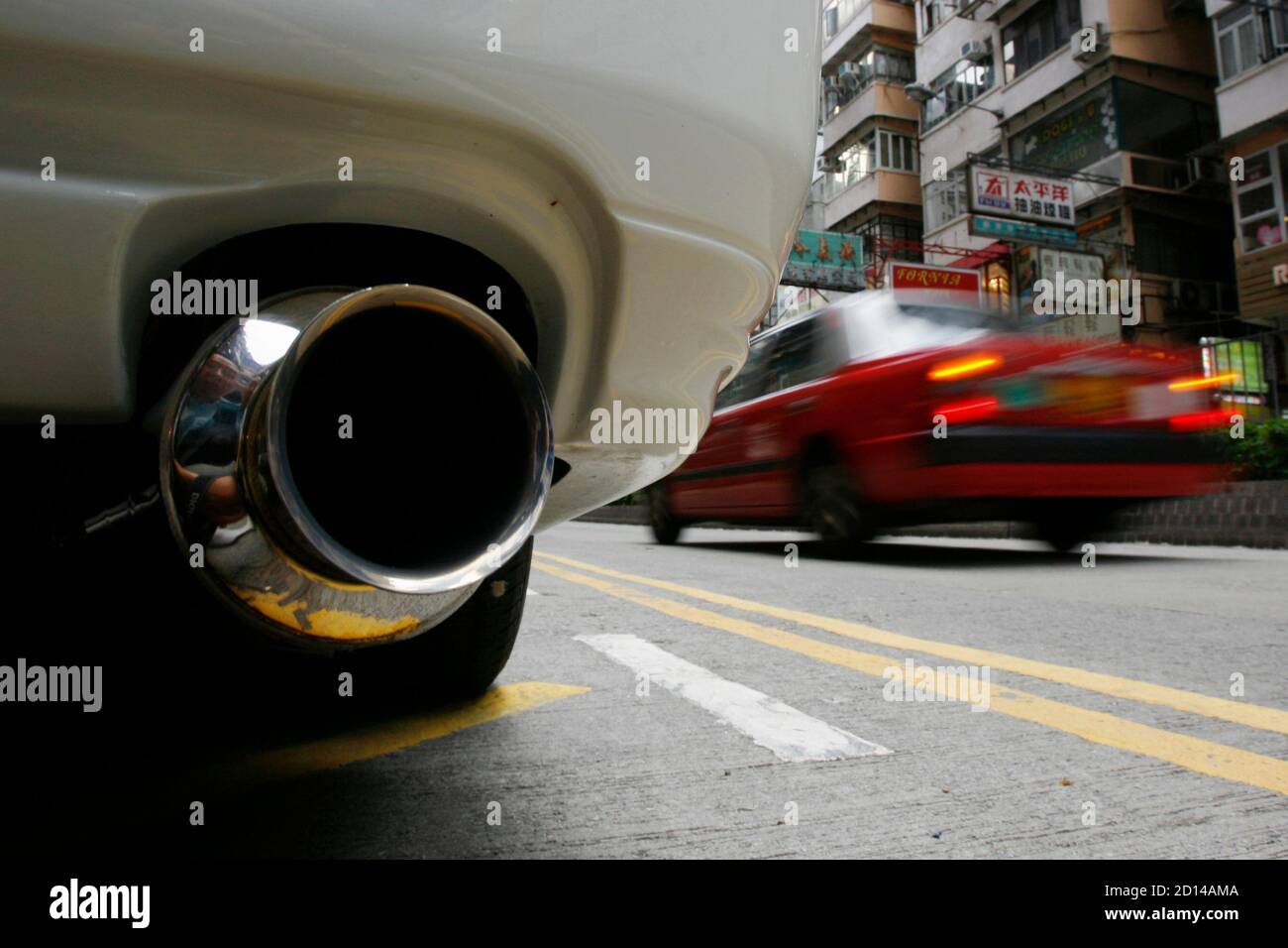 Ein Taxi geht von einem geparkten Fahrzeug auf einer Straße in Hongkong 15. Juli 2009. Luftverschmutzung in Hongkong hat das Sechsfache sprang in den vergangenen vier Jahren, aber Experten sagen lokale Fahrzeuge mehr Schuld als Smog eingeblasen vom südlichen China Herstellung Gürtel sind, eine Zeitung berichtete am Mittwoch.    REUTERS/Bobby Yip (CHINA-Politik-BUSINESS-Umgebung) Stockfoto